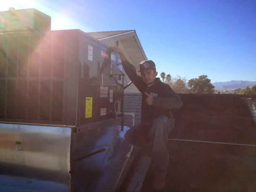 HVAC technician performing AC Tune-Up on a rooftop unit in Johnstown